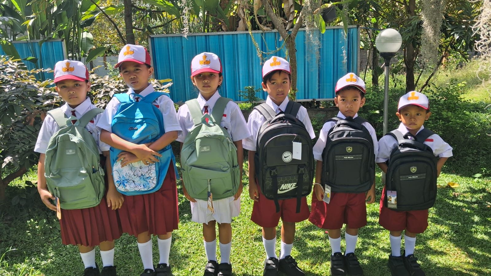 Zes kinderen van Futur in hun nieuwe schooluniform met rugzak